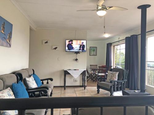 a living room with a tv on the wall at Hills and Dales Accommodation in Lanseria