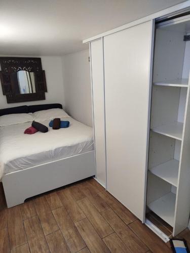 - une petite chambre avec un lit et un placard dans l'établissement Appartement individuel dans charmante maison de ville à la française, à Gagny
