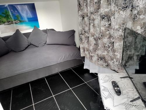 a room with a bed and a couch in a room at Appartement individuel dans charmante maison de ville à la française in Gagny