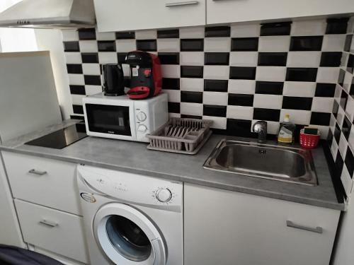 a kitchen counter with a sink and a microwave at Appartement individuel dans charmante maison de ville à la française in Gagny