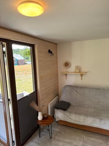 a bedroom with a bed and a large window at Domki Pod Jarzębiną Borsk in Borsk