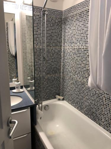 une salle de bain avec une baignoire, un lavabo et une douche dans l'établissement Charme, à Cannes La Bocca