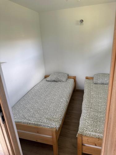 two beds in a small room withermottermottermott at Domki Pod Jarzębiną Borsk in Borsk