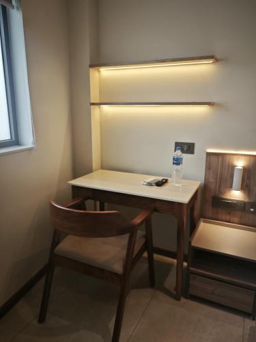a desk with a chair and a bottle of water on it at Alite Enclaves Fully furnished apartments in Trichūr