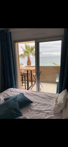 une chambre avec un lit et une vue sur l'océan dans l'établissement Charme, à Cannes La Bocca
