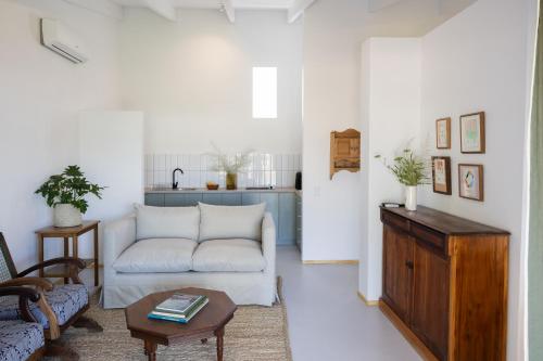 Stillewe Guest Cottages في Prince Alfreds Hamlet: غرفة معيشة مع أريكة بيضاء وطاولة