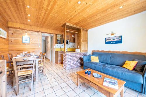un salon avec un canapé bleu et une table dans l'établissement Appartement Flocon, à Champagny-en-Vanoise