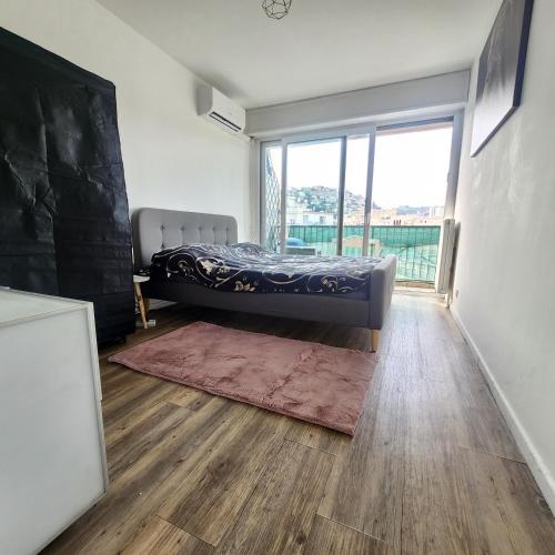 une chambre avec un lit et une grande fenêtre dans l'établissement Nice Centre - Plage, promenade des anglais, resto, vieille ville , tram tout à pied !, à Nice