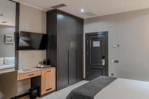 a bedroom with a bed and a flat screen tv at HUSMA Hotel & Spa in Tashkent