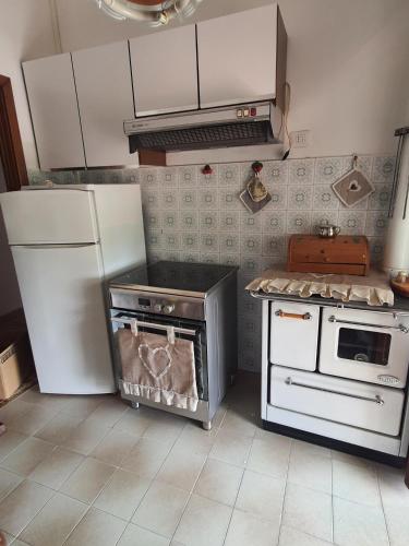 a kitchen with a stove and a refrigerator at Casa lorella in Santa Fiora
