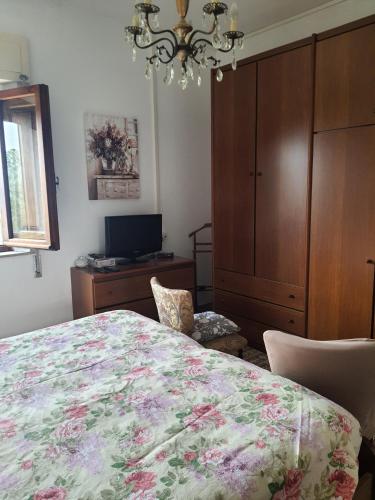 a bedroom with a bed and a cabinet and a chandelier at Casa lorella in Santa Fiora