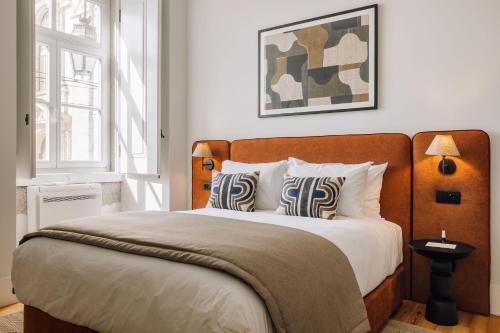 a bedroom with a large bed with white sheets and pillows at Ando Living - Corpo Santo House in Lisbon