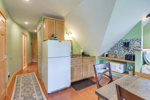 a kitchen with a white refrigerator and wooden cabinets at Shared Dock and Fire Pit Peaceful Surry Studio! in Surry