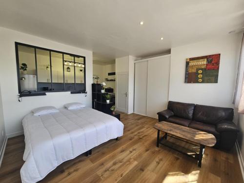 une chambre avec un lit et un canapé dans l'établissement L'atelier des Reves, à Fécamp