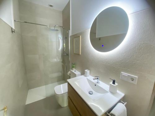 Un baño blanco con lavabo y espejo. en APARTAMENTOS TURÍSTICOS WAMBALORE, en Pampliega