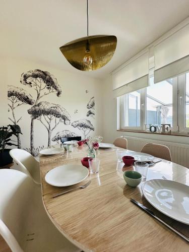 une salle à manger avec une table en bois et un lustre dans l'établissement L'Antre-Deux Maison 3 chambres avec jardin, à Charleville-Mézières
