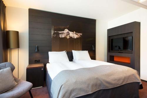 a bedroom with a large bed and a chair at Scandic Ørnen in Bergen