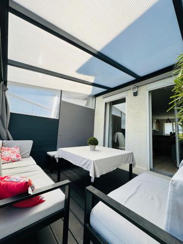 un patio avec une table, des chaises et une fenêtre dans l'établissement L'Antre-Deux Maison 3 chambres avec jardin, à Charleville-Mézières