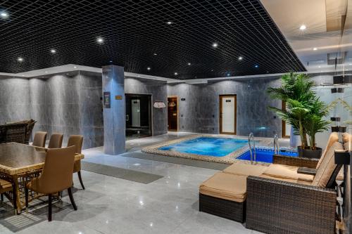 a pool in a room with a table and chairs at HUSMA Hotel & Spa in Tashkent