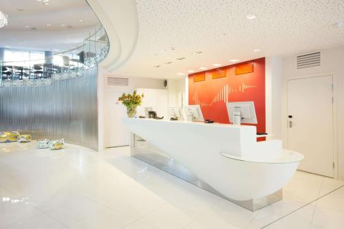 a lobby with a white counter and a red wall at Scandic Ørnen in Bergen