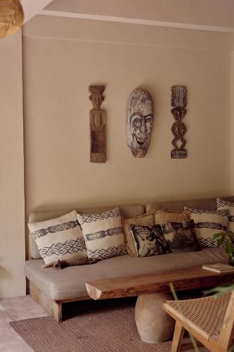 a living room with a couch and some pictures on the wall at Hani Hideaway in Gili Air