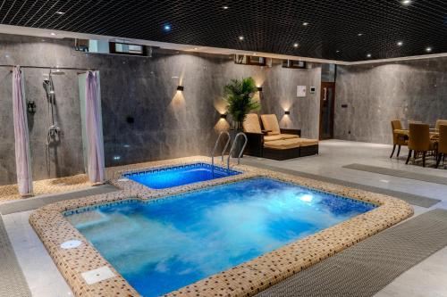 a large blue pool in a room with a shower at HUSMA Hotel & Spa in Tashkent