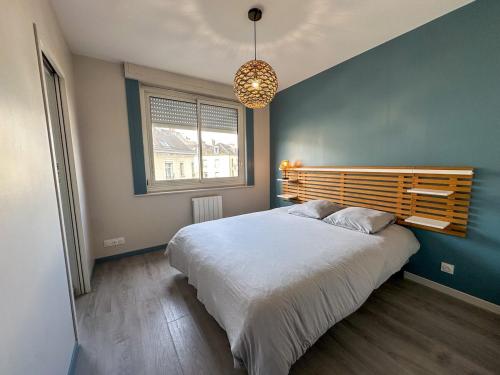 a bedroom with a large bed and a blue wall at Appartement T2 spacieux en plein coeur de Lorient in Lorient