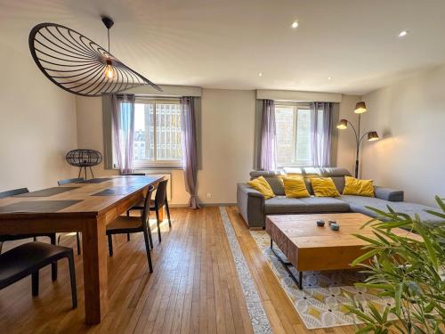 a living room with a table and a couch at Appartement T2 spacieux en plein coeur de Lorient in Lorient