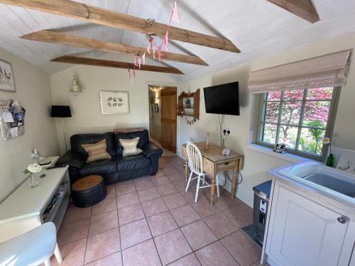 a living room with a couch and a table at Dairy Cottage Luxury B&B in Attleborough