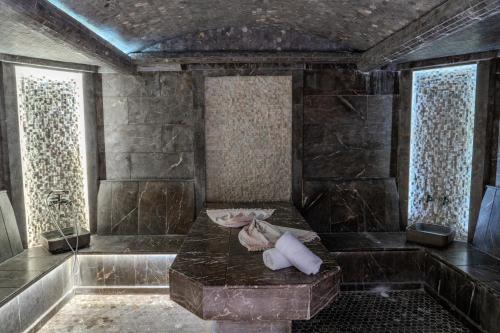 a room with a bath tub with a stone wall at HUSMA Hotel & Spa in Tashkent