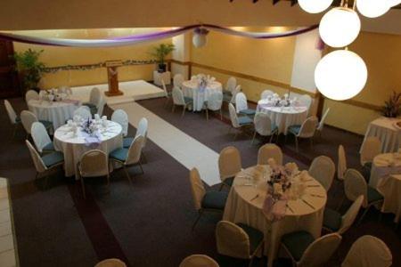 a banquet hall with white tables and chairs at Hotel Normandie Limited in Port-of-Spain