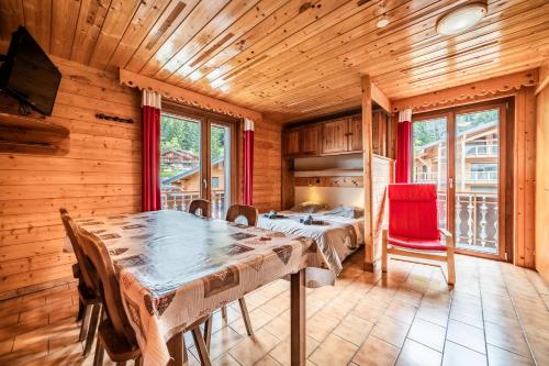 a dining room with a table and a bed at La Flèche d'Or in Châtel