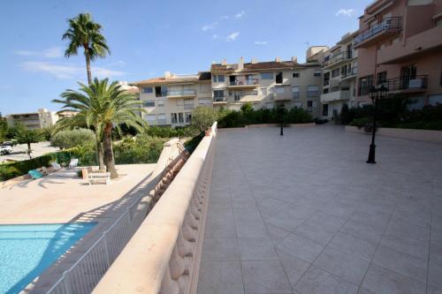 une passerelle à côté d'une piscine à côté d'un bâtiment dans l'établissement BELLEVUE HÉRACLÉE, à Saint-Tropez