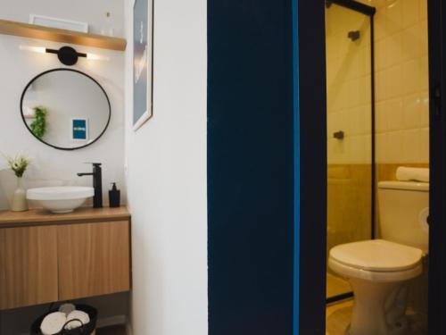a bathroom with a toilet and a sink and a mirror at Apê Santos Praia do Gonzaga in Santos