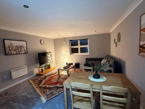 a living room with a table and a living room with a couch at 2 Bed - Sleeps 6 - Free Parking - Town Centre in Bracknell