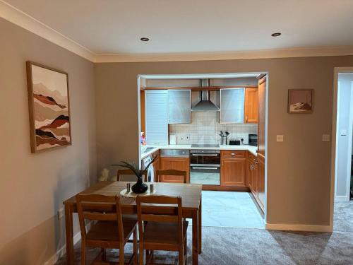a kitchen with a wooden table and a dining room at 2 Bed - Sleeps 6 - Free Parking - Town Centre in Bracknell