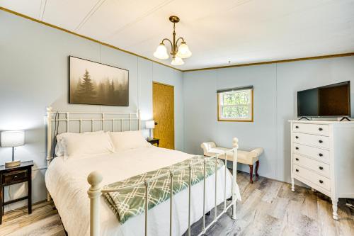 a bedroom with a bed and a tv and a dresser at Hike, Fish and Ski Black Bear Cabin in Albany in Albany