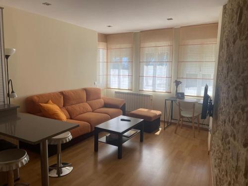 una sala de estar con un sofá y una mesa en Apartamento céntrico O Castelo, en Pobra do Caramiñal