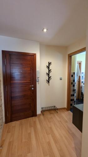 a room with a wooden door and a wooden floor at Apartamento céntrico O Castelo by Cristian&Tamara "alquileres" in A Pobra do Caramiñal