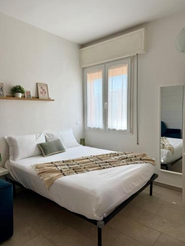 a large bed in a room with a window at A due passi dal mare - OpenSpace in Porto Garibaldi