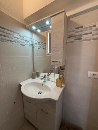 a bathroom with a sink and a mirror at A due passi dal mare - OpenSpace in Porto Garibaldi