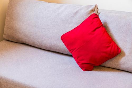 a red pillow sitting on top of a couch at Flexible SelfCheckIns 172 - Zagreb - Center - New in Zagreb