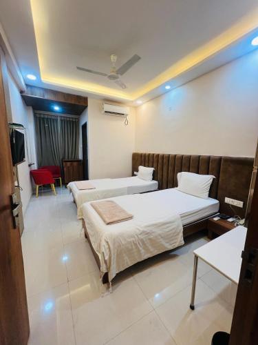a hotel room with two beds and a television at Shree 9NB Hotels, Pithampur in Indore