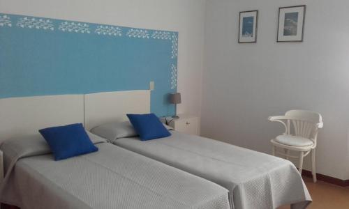 Un dormitorio con una cama con paredes azules y una silla en Casa Palmira, en Brenzone sul Garda