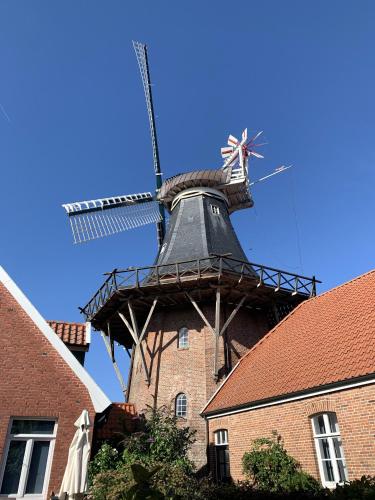 a windmill on top of a brick building at Ferienwohnung Tichelmeister 45261 in Ditzum