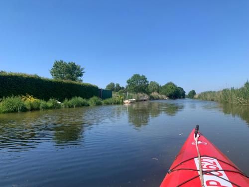 a red kayak is on a river at Ferienwohnung Tichelmeister 45261 in Ditzum