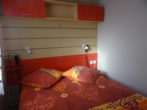 a bedroom with a bed with two pillows at Mobilhome confortable in La Celle-sous-Gouzon