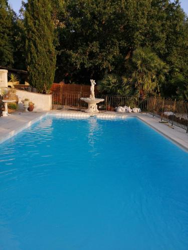 une grande piscine bleue avec une fontaine dans la cour dans l'établissement 2 Pièces ZEN dans villa en pleine nature, à Antibes
