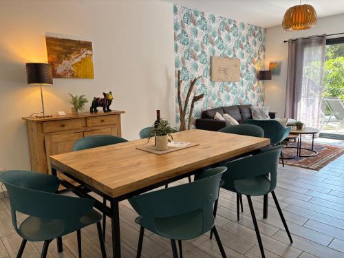 une salle à manger avec une table et des chaises en bois dans l'établissement Du sable et des pins, au Le Verdon-sur-Mer