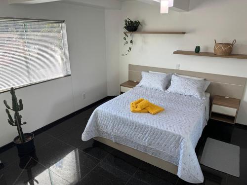 a bedroom with a bed with a yellow towel on it at Hospedaria Sewald in Treze Tílias